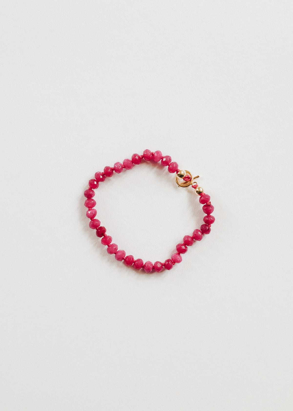 Pink beaded bracelet with 14k gold-filled accents and a toggle closure.