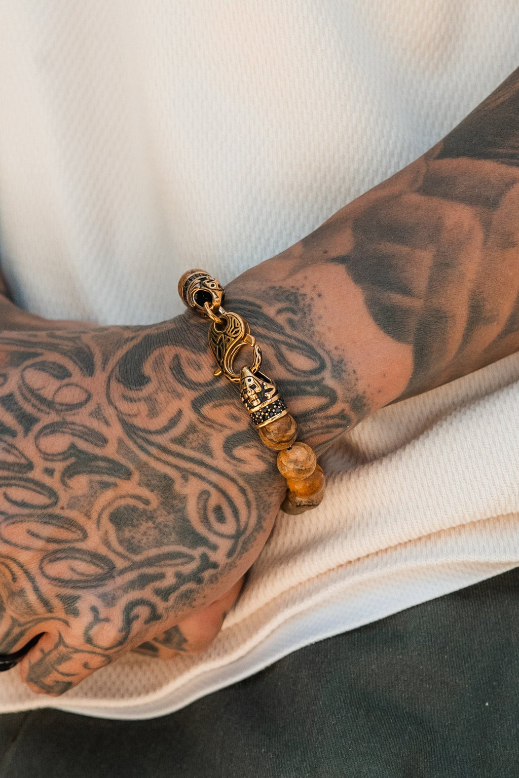Desert Storm Gemstone GOLD Ed. Bracelet: brown marbled round beads with decorative gold-tone clasp, clasp detail on a wrist.
