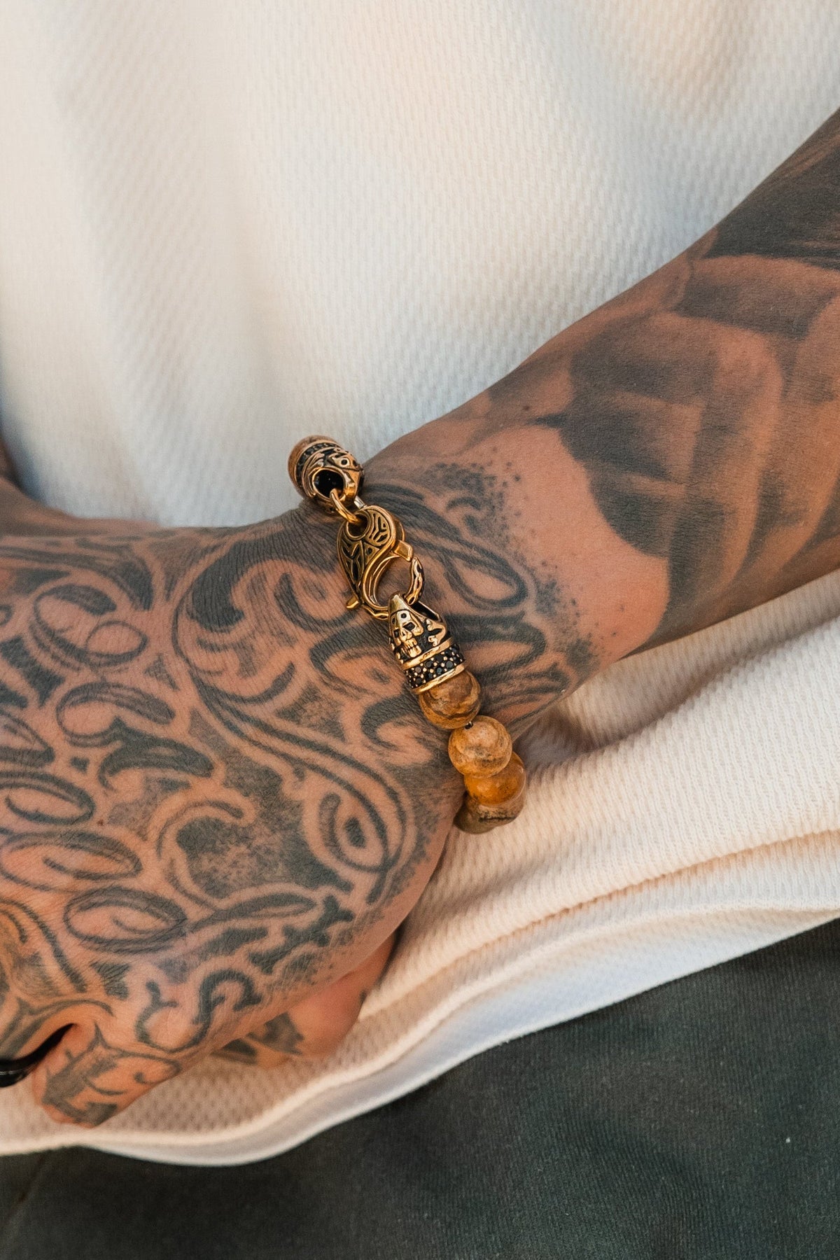 Desert Storm Gemstone GOLD Ed. Bracelet: brown marbled round beads with decorative gold-tone clasp, clasp detail on a wrist.