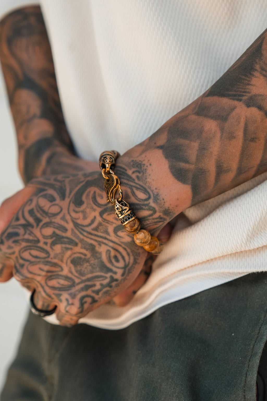 Desert Storm Gemstone GOLD Ed. Bracelet: brown marbled round beads with decorative gold-tone clasp, worn on a wrist.