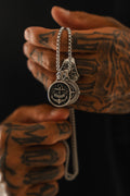 Reckless Soul Necklace: paired round anchor and compass-rose pendants on a silver-tone chain, held by its chain.