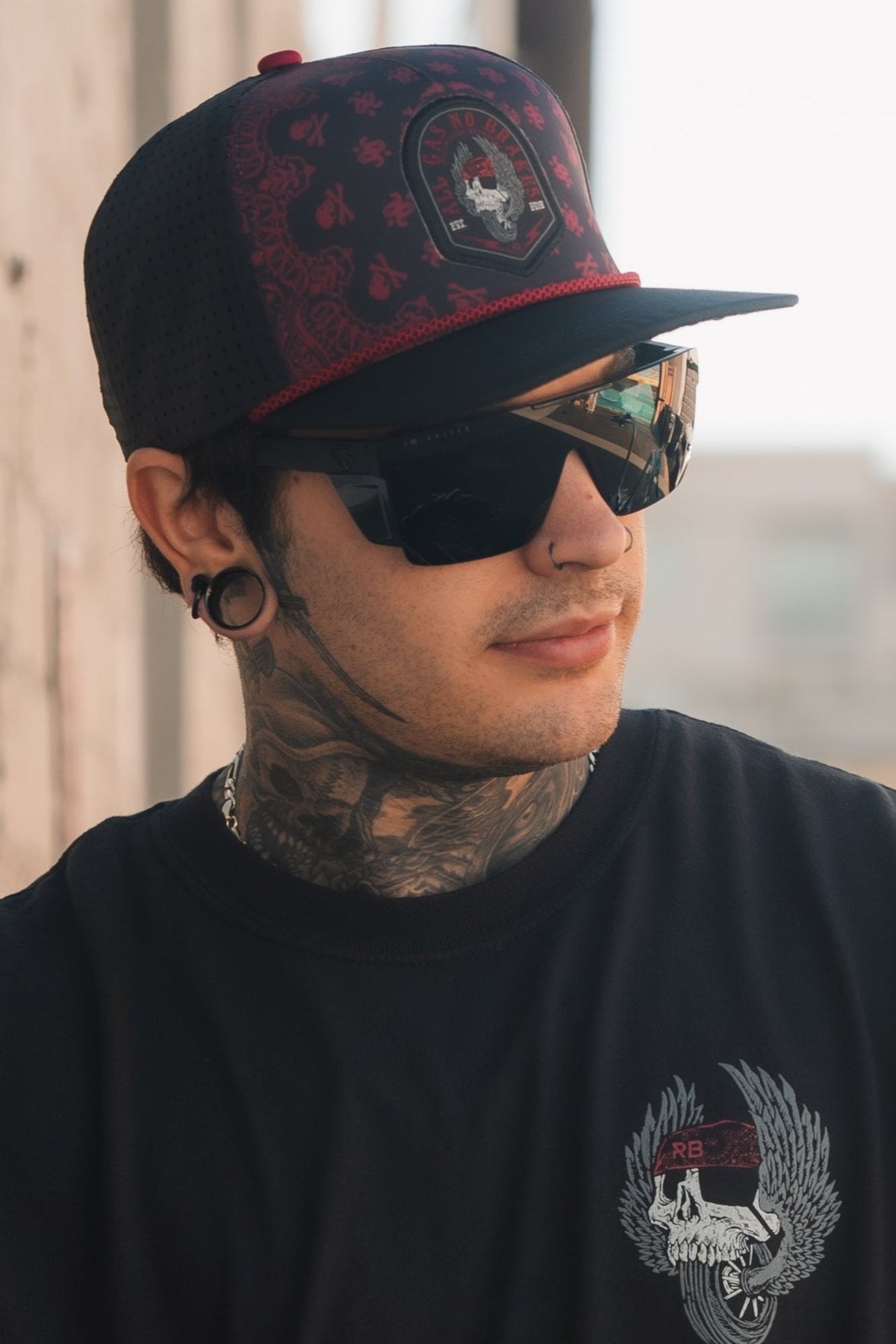 All Gas No Brakes Premium Snapback: black cap with red bandana-style print, skull patch and red rope trim, side view on a model.