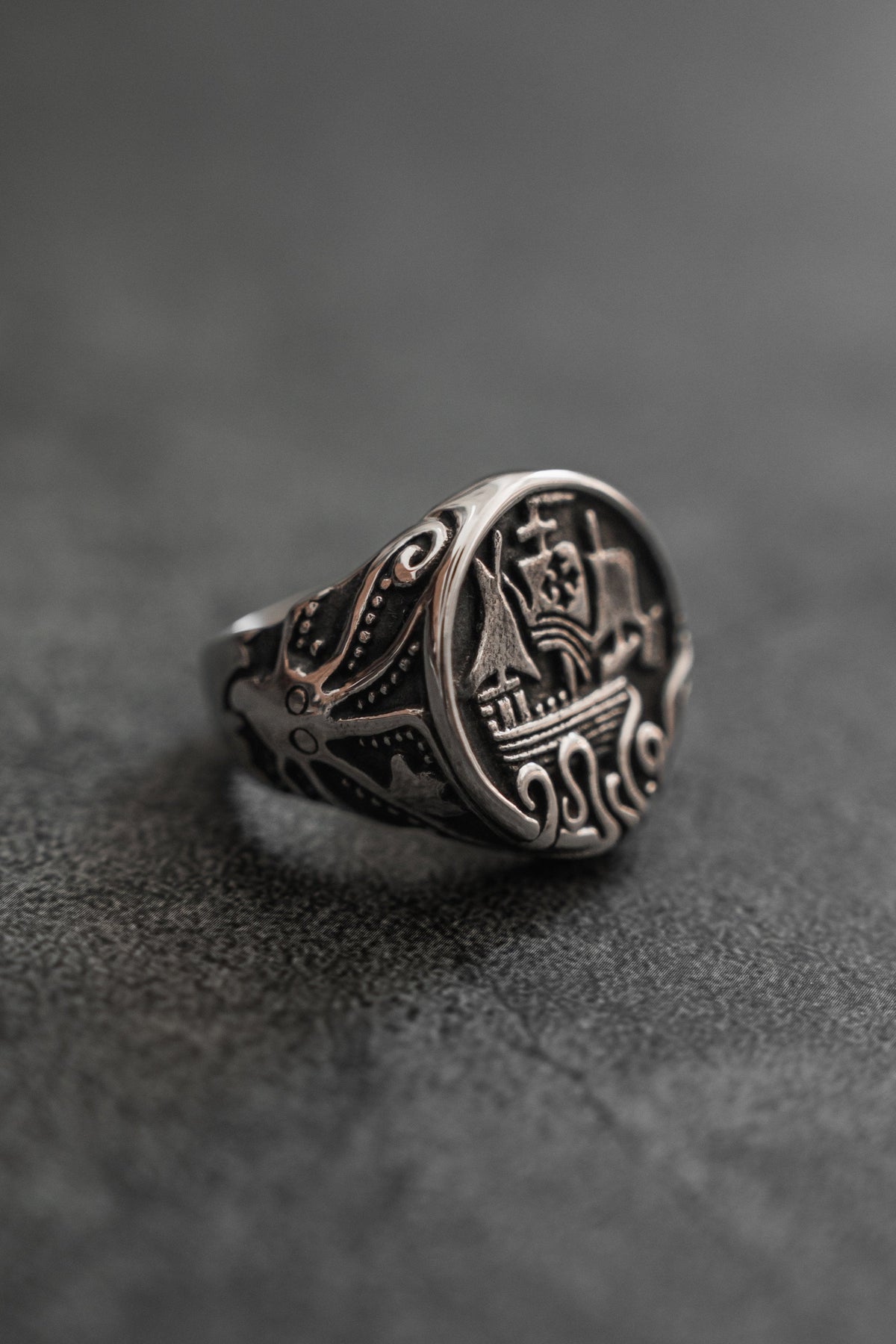 The Rise of the Kraken Ring: round signet face with a sailing ship and curling tentacles, angled product view.