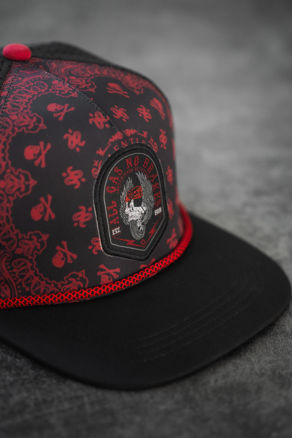 All Gas No Brakes Premium Snapback: black cap with red bandana-style print, skull patch and red rope trim, angled front detail.