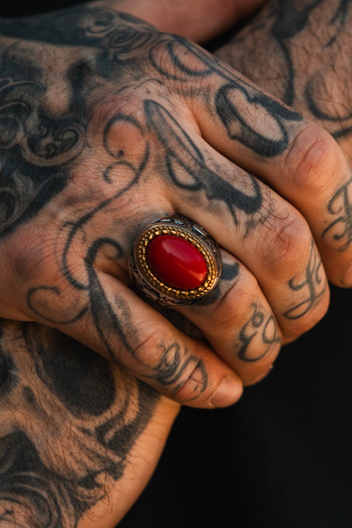 Burning Rose Ring: oval red center, gold-tone border and detailed silver-tone band, worn on a hand.