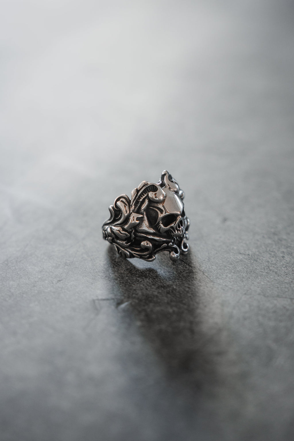 Gravewater Ring: sculpted skull with ornate curling side details, side view.