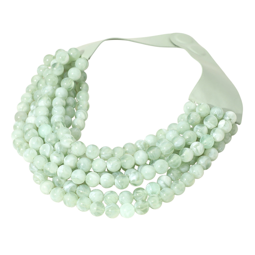 Chunky multi-strand beaded statement necklace shown in an additional colorway on a display form