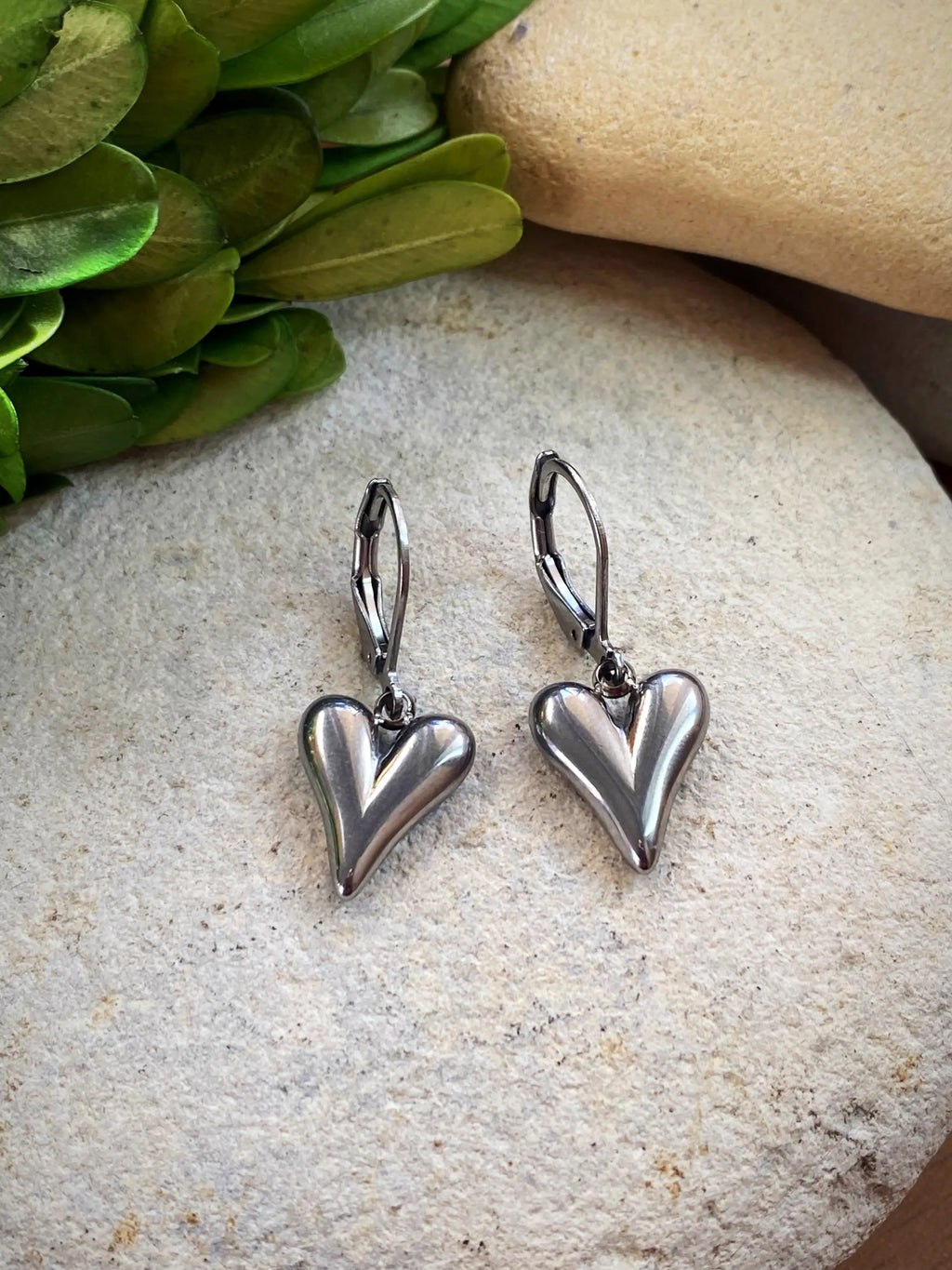 Silver-Tone Heart Earrings displayed in a hand