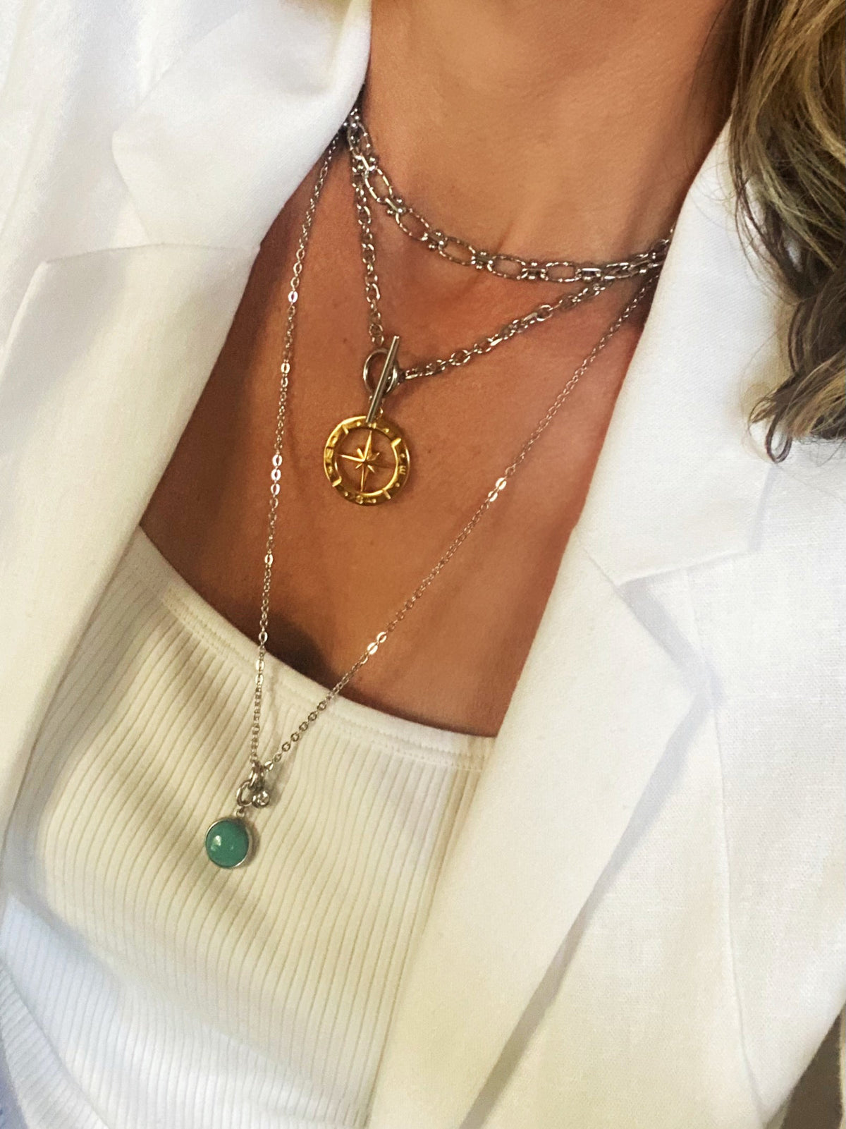 Stone Charm Necklace in the green colorway worn layered with other necklaces, styled with a white blazer (additional necklace and pendant shown are not included in this listing)