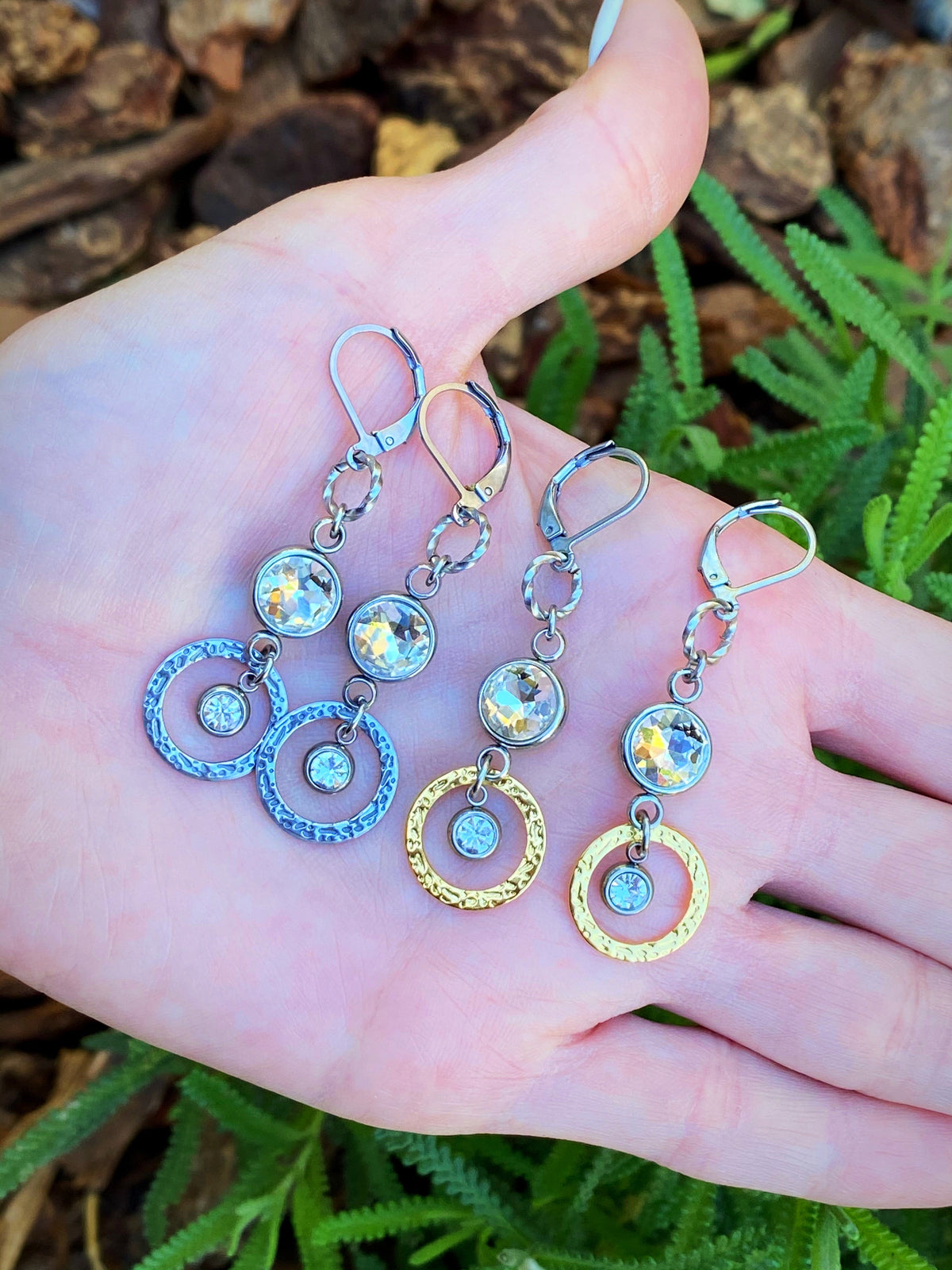 Venus Sunlight Rhinestone Drop Earrings displayed in a hand