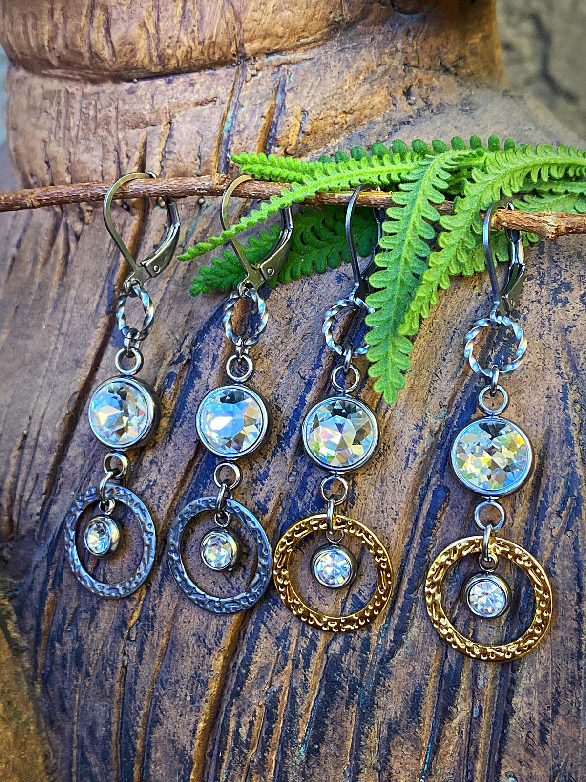 Venus Sunlight Rhinestone Drop Earrings in both finish options on wood