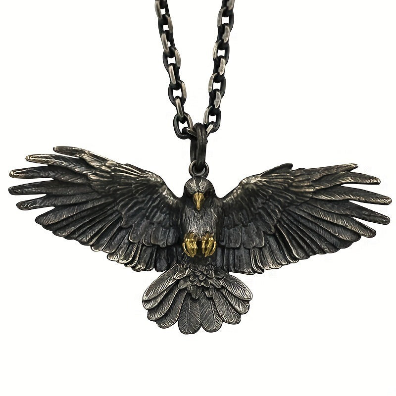 Falcon pendant with wings spread on a metal chain, shown against a white background with gold-tone beak and talon accents visible