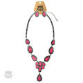 Fuchsia-pink concho necklace and matching earrings on a wood background, showing the teardrop and oval stone clusters