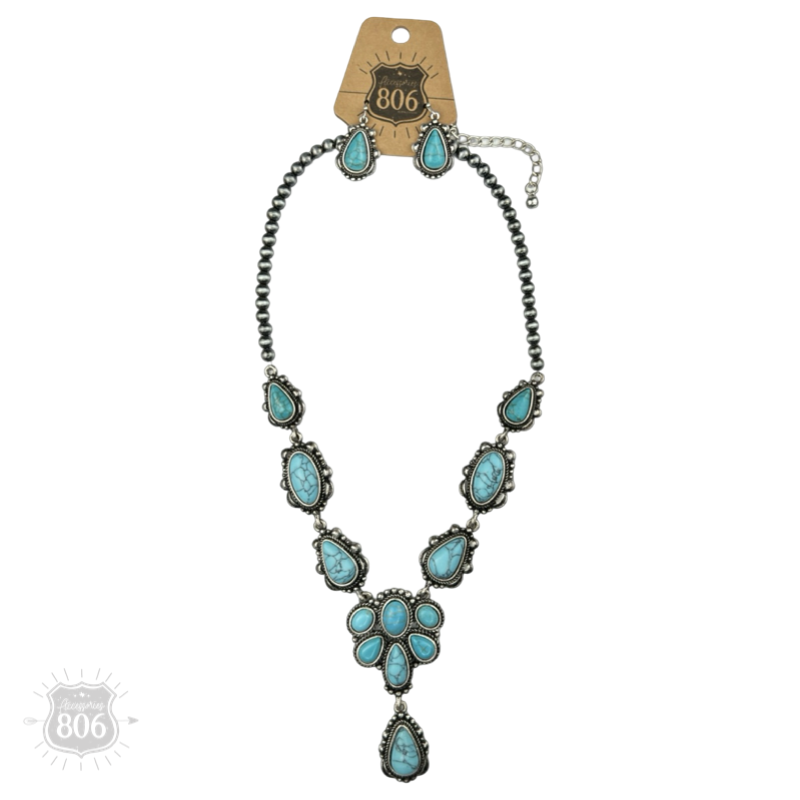 Turquoise-color concho necklace and matching earrings on a hang tag, showing the bead chain, stone clusters, and extender chain