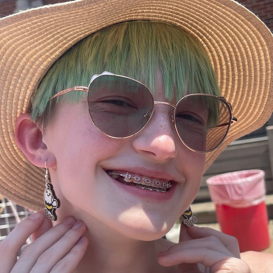 Close-up of a model wearing the Boo Bees ghost-bee wooden earrings