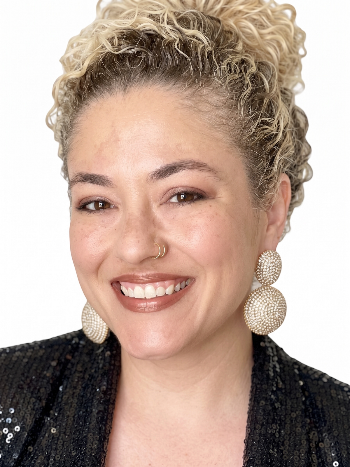 Dopamine Alley double-disc drop earrings with pavé crystals worn by a smiling woman with curly blonde hair