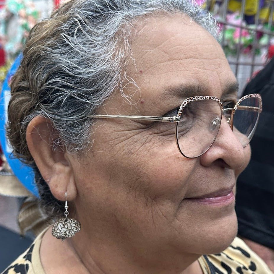 Model wearing a wooden brain-shaped dangle earring, profile view