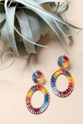 Close-up of the Rainbow Raffia Hoop Earrings worn on the ear, showing the double-hoop raffia wrap in multiple colors