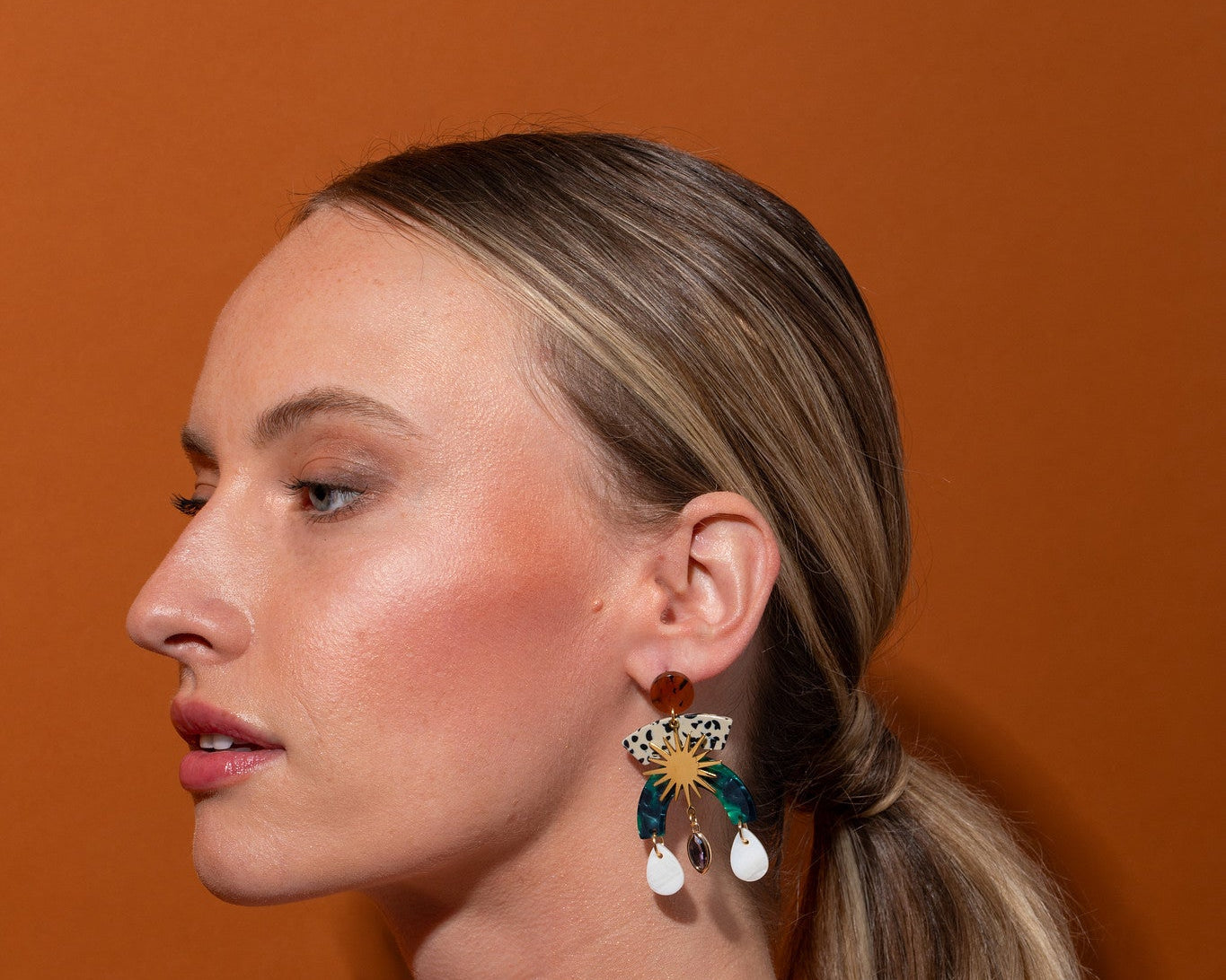 Model wearing the Sunburst Shell Drop Statement Earrings in profile, showing the multi-tier drop against her hair