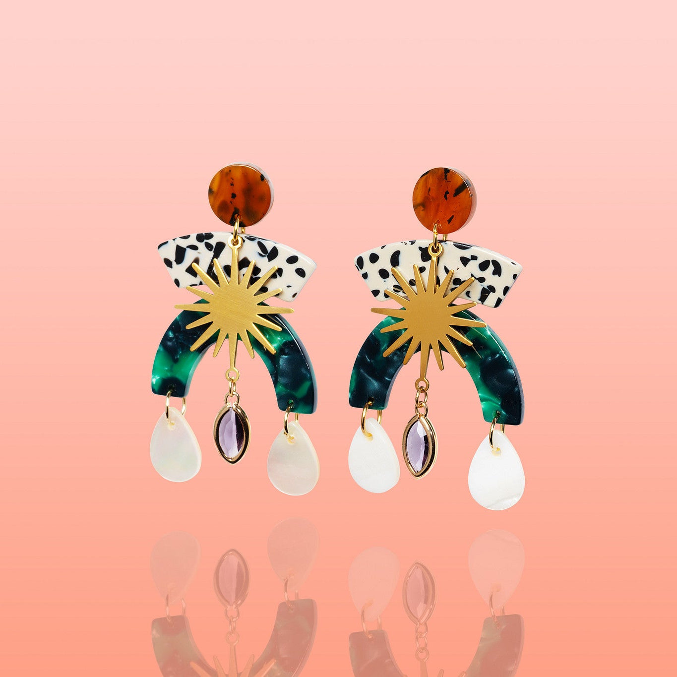 Pair of Sunburst Shell Drop Statement Earrings laid flat, showing the tortoiseshell-effect stud, black-and-white spotted arc, gold sunburst, green marbled arch, and shell and stone drops